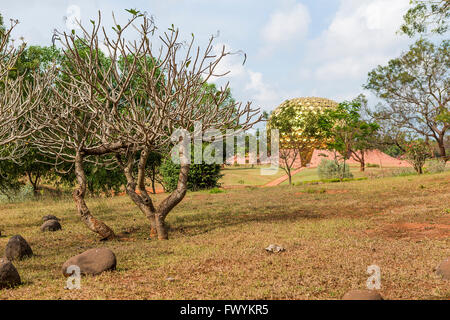 Le Matrimandir à travers les arbres à Auroville, une ville située dans le district Viluppuram expérimental dans l'Etat du Tamil Nadu, Banque D'Images