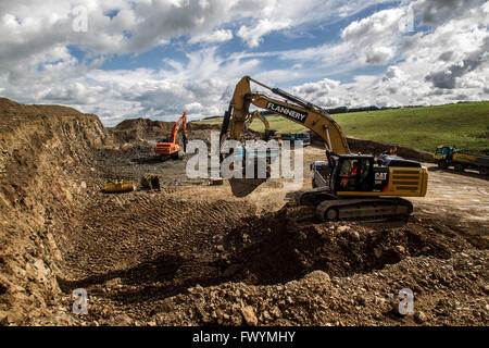 La construction de chemins frontières montrant diggers clearing rocks Banque D'Images