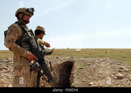 Mossoul, Irak. Apr 9, 2016. Deux soldats se tiennent près de tunnels souterrains découvert par les forces de l'armée iraquienne après ils ont libéré l'Khrbadan village depuis la saisie de l'État islamique (EST), dans la ville de Qayyarah, 55 km au sud de Mossoul, en Irak, le 9 avril 2016. © Yaser Jawad/Xinhua/Alamy Live News Banque D'Images