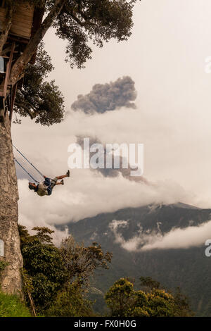 Banos de Agua Santa, - 08 mars 2016 : Silhouette d'un jeune adolescent Garçon sur une balançoire se balancer au-dessus des montagnes des Andes, T Banque D'Images