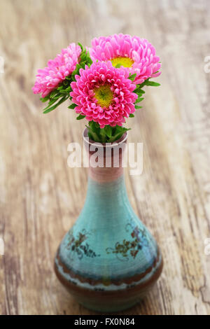 Pink daisies in fine sur la surface en bois vase en porcelaine Banque D'Images