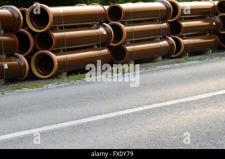 Les tuyaux de cheminées à côté de route asphaltée. Banque D'Images