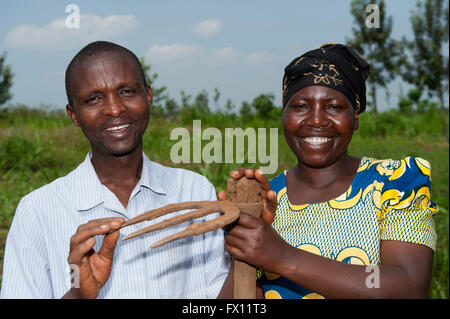 Couple d'agriculteurs rwandais avec une houe utilisée dans les domaines de lutte contre les mauvaises herbes cultures. Banque D'Images