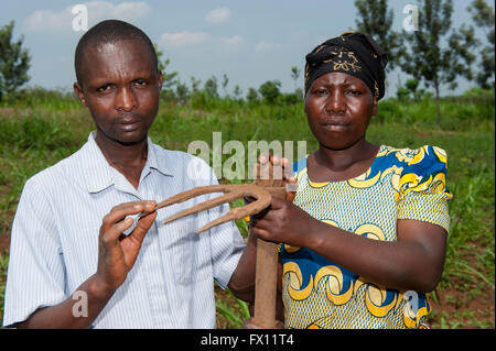 Couple d'agriculteurs rwandais avec une houe utilisée dans les domaines de lutte contre les mauvaises herbes cultures. Banque D'Images