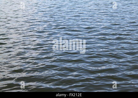 La lumière du soleil sur le fond de l'eau ondulante doucement ou de texture Banque D'Images