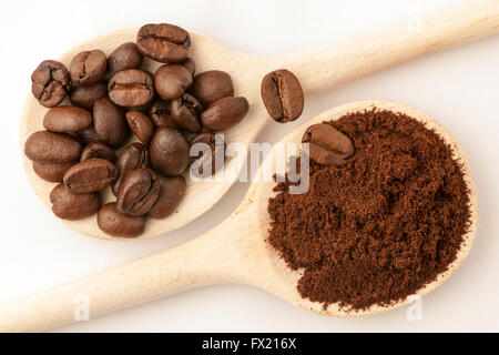 Côté opposé deux cuillère en bois remplis de grains de café et blanc poudre de café Banque D'Images