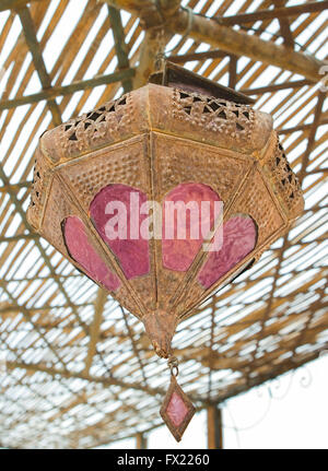 Old rusty vintage lampe arabe métallique accroché au plafond d'un riad marocain Banque D'Images