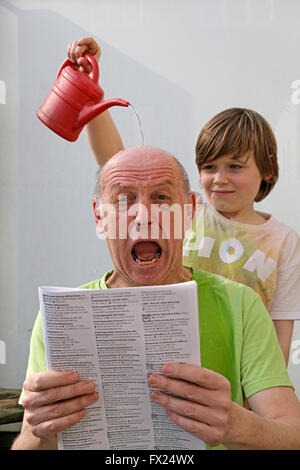 Naughty boy verser de l'eau sur la tête d'un homme Banque D'Images