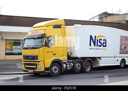 DHL un camion Volvo FH tirant une remorque du CSRN se trouve en face d'un dépanneur pour décharger. Banque D'Images