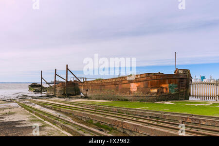 Ship yard désaffecté avec fer à l'abandon de navires et la rouille rails pour tous les bateaux de treuillage flanquée de bancs de boue l'estuaire Humber. Banque D'Images