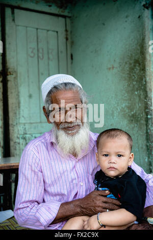 Grand-père indien tient son petit-fils à Baiganwadi slum, Mumbai Banque D'Images