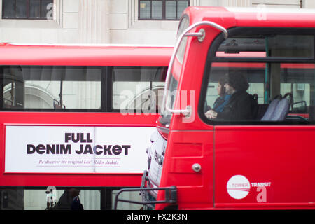 Red London bus exploité par Tower Transit, Londres avec Lee Rider pleine publicité de veste en denim Banque D'Images