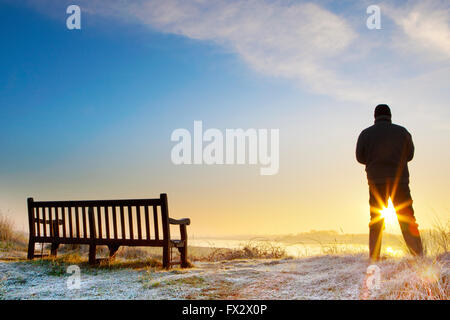 Marshside réserve naturelle, Southport, Lancashire, Royaume-Uni. 10 avril, 2016. Météo britannique. Après une nuit glaciale et froid, un beau lever de soleil apparaît sur les milieux humides de la réserve naturelle de Marshside RSPB à Southport. Un homme se profile comme il considère le lever du soleil dans le réchauffement de l'air frais du printemps à l'aube. Credit : Cernan Elias/Alamy Live News Banque D'Images