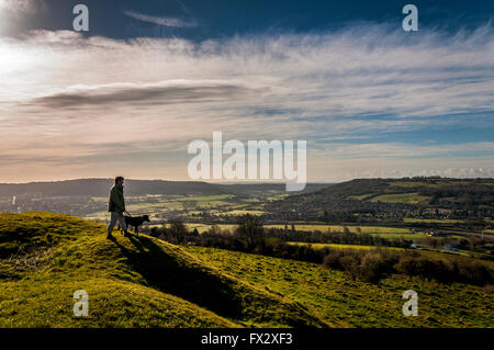 Peu de Solsbury Hill, Batheaston, Somerset, UK . Un chien walker admire la vue depuis le haut de l'ancien fort de l'âge du fer a été rendu célèbre dans la chanson 'Solsbury Hill' par Peter Gabriel. Banque D'Images