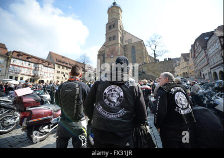 Schwaebisch Hall, en Allemagne. 10 avr, 2016. Deux hommes portant des vestes de leurs clubs de moto se tiennent près de leurs motos en face de l'église Saint-Michel à Schwaebisch Hall, Allemagne, 10 avril 2016. Un service d'église traditionnelle pour les motocyclistes a lieu chaque année au début de la nouvelle saison de motocyclisme pour rappeler aux amateurs de les joies et les dangers de ce sport. Photo : JAN-PHILIPP STROBEL/dpa/Alamy Live News Banque D'Images