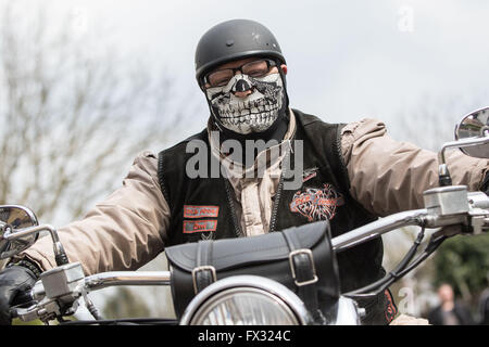 Niedergruendau, Allemagne. 10 avr, 2016. Un motard portant un masque représentant un crâne s'assied sur son véhicule à la 35e 'Anlassen' (lit. Démarrage d'un moteur) marquant le début de la nouvelle saison de moto, en Niedergruendau, Allemagne, 10 avril 2016. Photo : FRANK RUMPENHORST/dpa/Alamy Live News Banque D'Images