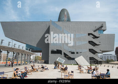 Les gens assis sur des chaises longues sur la plaza,carré avec le Design Museum et Tour Agbar à Barcelone, Catalogne, Espagne,. Banque D'Images