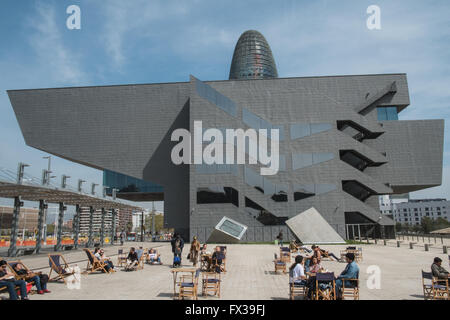 Les gens assis sur des chaises longues sur la plaza,carré avec le Design Museum et Tour Agbar à Barcelone, Catalogne, Espagne,. Banque D'Images