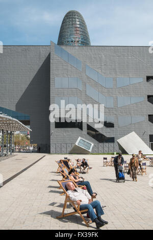 Les gens assis sur des chaises longues sur la plaza,carré avec le Design Museum et Tour Agbar à Barcelone, Catalogne, Espagne,. Banque D'Images