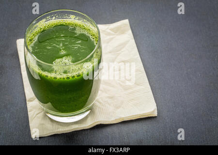 Jus de légumes verts frais de concombre, les épinards et le chou - un verre avec serviette sur un fond noir en ardoise Banque D'Images