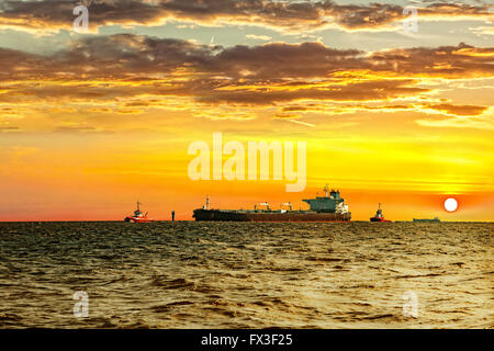 Les remorqueurs d'escorte avec des pétroliers en mer au coucher du soleil. Banque D'Images