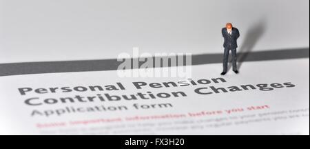 Un homme d'affaires figurine miniature debout sur un formulaire de demande des changements aux régimes de retraite Banque D'Images