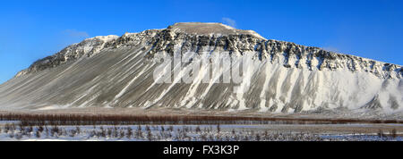 Neige de l'hiver sur les champs de lave et une vue sur la montagne Hafnarfjall, près de la ville de Borgarnes, Région de l'ouest de l'Islande Banque D'Images