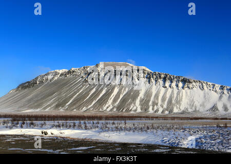 Neige de l'hiver sur les champs de lave et une vue sur la montagne Hafnarfjall, près de la ville de Borgarnes, Région de l'ouest de l'Islande Banque D'Images