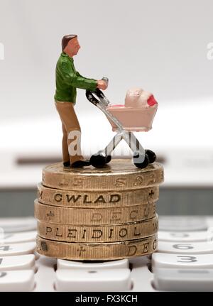 Un seul mâle figurine miniature parent avec un landau debout sur pièces livre et une calculatrice Banque D'Images