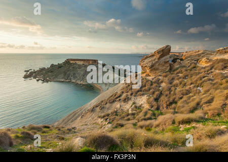 Coucher du soleil à Gnejna Bay près de Manikata, Malte. Banque D'Images