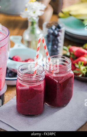 Deux pots avec berry smoothie, fruits frais en arrière-plan. Manger un régime propre et concept Banque D'Images