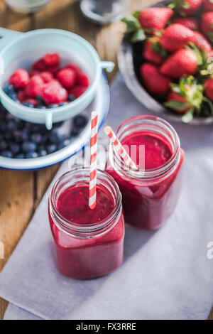 Les régimes et le bien-être concept, berry smoothie en pot, vue du dessus sur table en bois dans la cuisine ensoleillée Banque D'Images