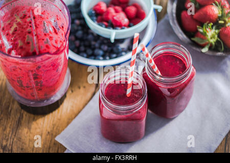 Les régimes et le bien-être concept, berry smoothie en pot, vue du dessus sur table en bois dans la cuisine ensoleillée Banque D'Images