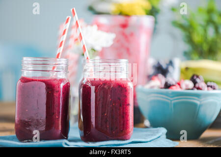 Smoothie fraîchement mélangé, dans la cuisine ensoleillée sur table de ferme. L'espace négatif pour le texte, les ingrédients et les fruits frais en backgrou Banque D'Images