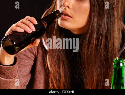 La fille est de boire de l'alcool à partir d'une bouteille. Banque D'Images