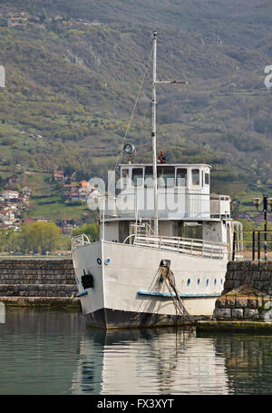 Un bateau blanc avec mât ancré à l'embarcadère du lac Banque D'Images