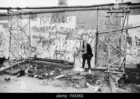 Image d'archive d'une jeune femme en face de graffitis sur les vestiges du Mur de Berlin, la Potsdamer Platz, Berlin, Allemagne, mars 1994. Autorisation modèle disponible. Banque D'Images