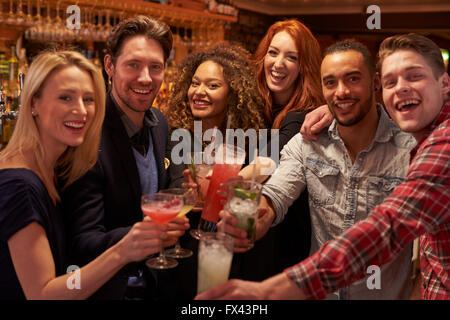 Réunion du Groupe des amis pour prendre un verre en soirée au bar à cocktails Banque D'Images