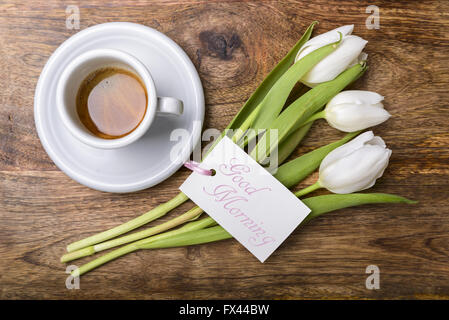 Tasse de café, de tulipes blanches et de carte avec bon matin écrit sur table en bois Vue de dessus Banque D'Images