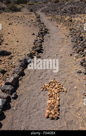 Flèche sur le terrain faite de petites pierres sur une balade à vélo dans le quartier de Las Canadas del Teide national park, Tenerife, Canary Island Banque D'Images