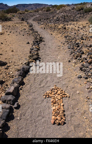 Flèche sur le terrain faite de petites pierres sur une balade à vélo dans le quartier de Las Canadas del Teide national park, Tenerife, Canary Island Banque D'Images