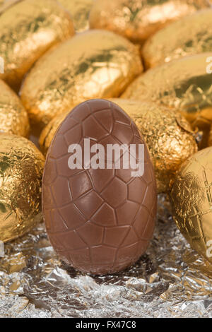 Plus d'indulgence dans les oeufs de Pâques en chocolat enveloppé dans la feuille d'or brillant dans les lignes prêt pour problème de santé surpoids chocoholic Banque D'Images