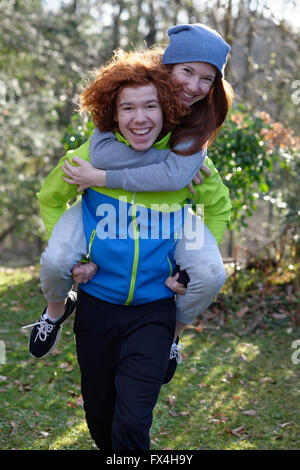 Jeune fille portant sa soeur sur son dos, rousse de ferroutage, frères et sœurs, Bavière, Allemagne Banque D'Images