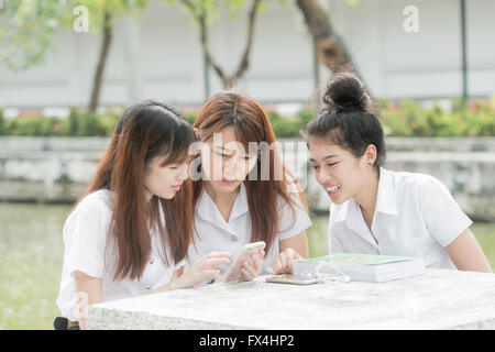 Portrait de groupe d'élèves s'amusant avec les smartphones après la classe. Banque D'Images
