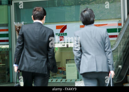 Les gens passent devant un sept & Co. iHoldings pancarte sur l'affichage à l'extérieur de son siège social le 11 avril 2016, Tokyo, Japon. Toshifumi Suzuki, sept iHoldings Co. président-directeur général a brusquement annoncé sa démission lors d'une conférence de presse le jeudi après que la compagnie a rejeté sa proposition de remplacer Ryuichi Isaka, président de 7-Eleven au Japon. Isaka était considéré comme un successeur potentiel de Suzuki à la tête du groupe du détail et on a dit que Suzuki a essayé d'Isaka déposer afin d'ouvrir la voie à son fils à prendre la relève dans l'avenir. (Photo de Rodrigo Reyes Marin Banque D'Images