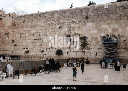 Jérusalem, Israël. 12 avril, 2016. Le rabbin du Mur occidental et des lieux saints en Israël, le Rabbin Rabinovitch, supervise une équipe d'employés dans l'élimination de la prière relève dans les crevasses du Mur occidental à la veille de la Pâque juive. La prière des notes sont effacées deux fois par an et cérémonieusement enterré dans le cimetière juif sur le Mont des Oliviers à Jérusalem. Credit : Alon Nir/Alamy Live News Banque D'Images