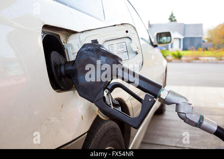 Une pompe à essence est pompiste dans cette voiture à la station d'essence pendant le ravitaillement. Banque D'Images