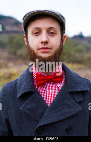 Hipster tendance guy à l'extérieur l'hiver dans un fashion portrait du bel homme. Banque D'Images