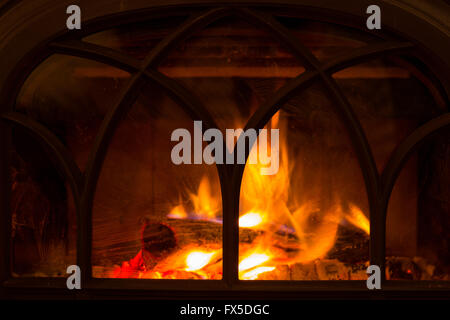 Le feu brûle dans un poêle à bois dans un lodge de montagne. Banque D'Images