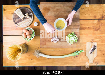 La préparation des pâtes carbonara's. Les mains le mélange d'œufs, le sel et le fromage parmisan. Banque D'Images